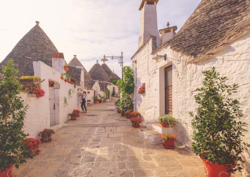 Young woman preparing the shop to open in Alberobello Puglia