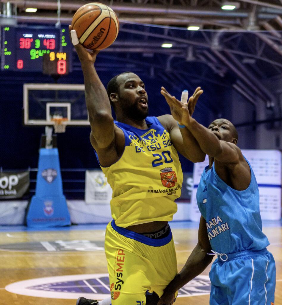 Sibiu player trying to score against Voluntari in a basketball game in Voluntari Romania