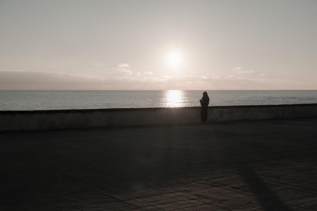 Girl admiring the sunset in Cadiz Andalusia