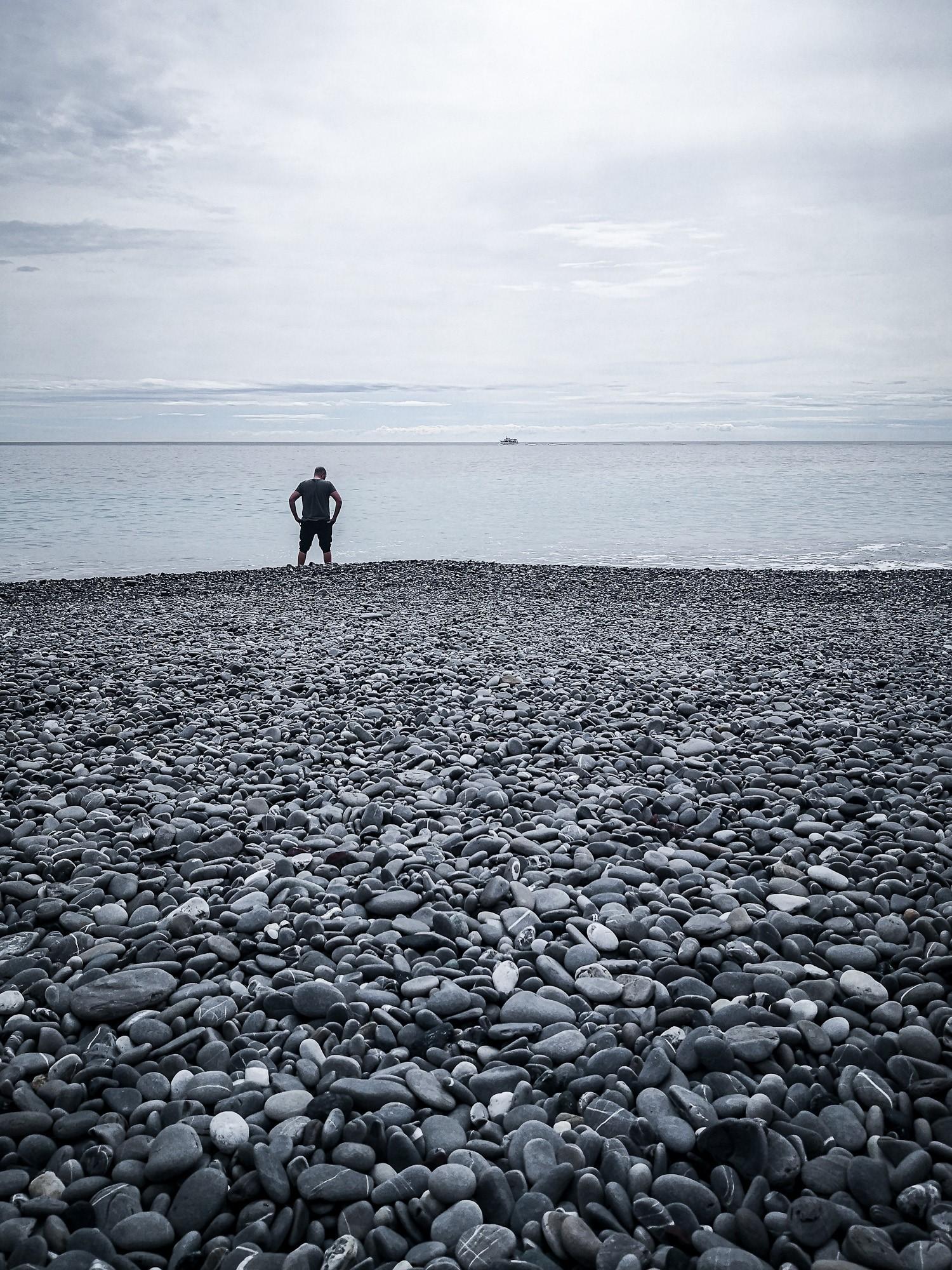Lone figure on Camogli beach on a cloudy day Italy