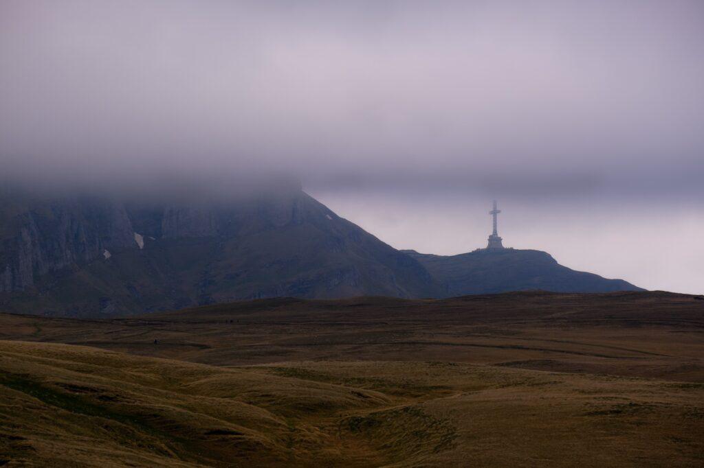 The Caraiman Cross visible through fog in the Bucegi Mountains