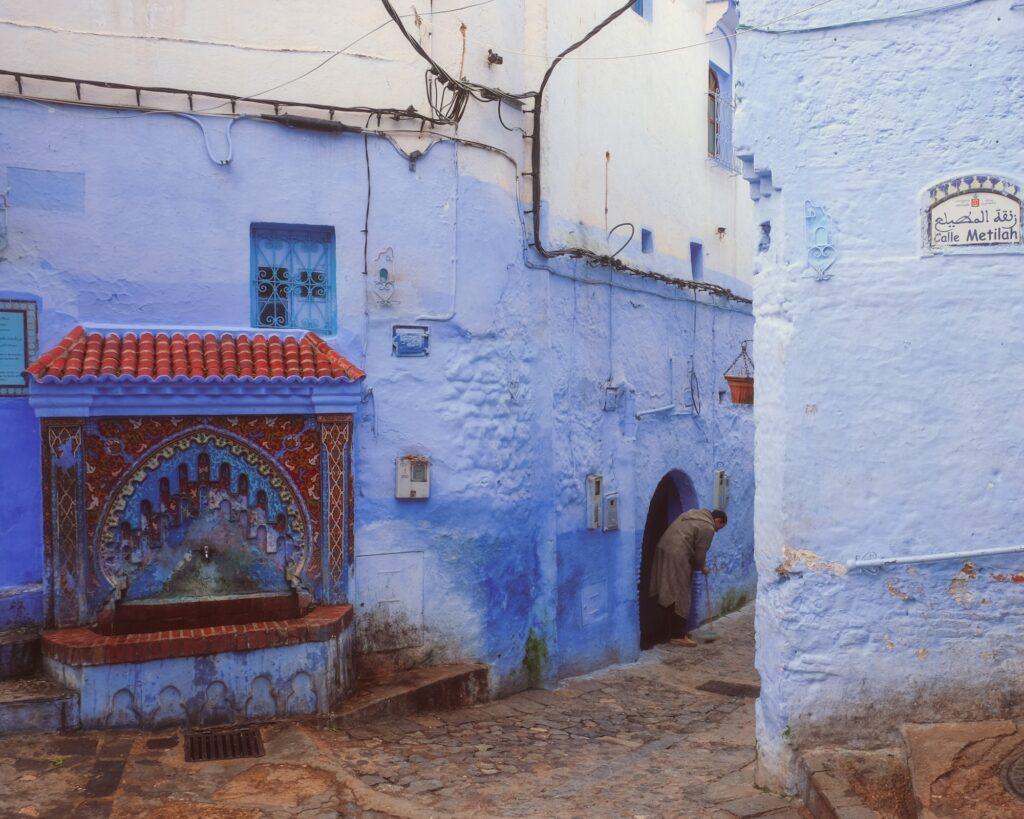 Man cleaning in front of his house in Chefchaouen Morocco