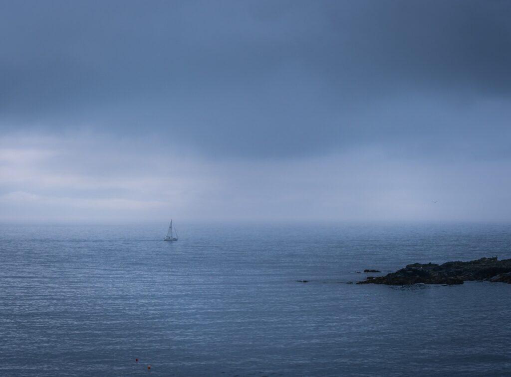 Calm sea and a lonely boat along the coast of Cornwall in England