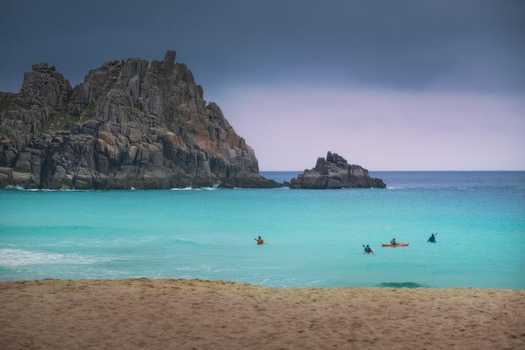 Cloudy day and people enjoying kayaking on the Cornwall coast in England