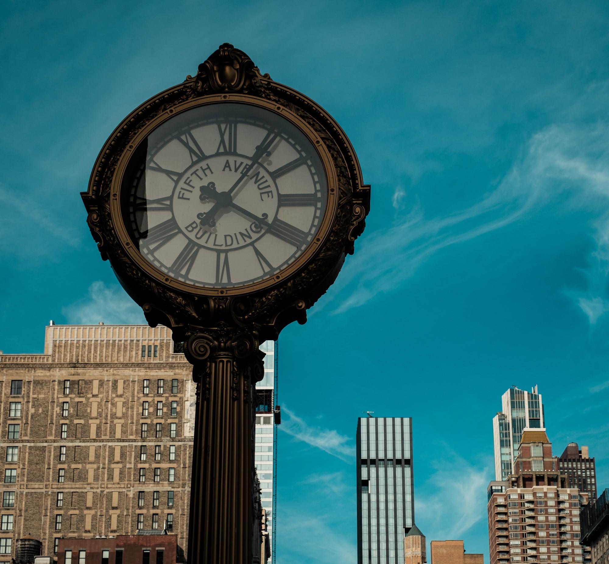 Street photography scene in the Flatiron District New York with vintage street clock