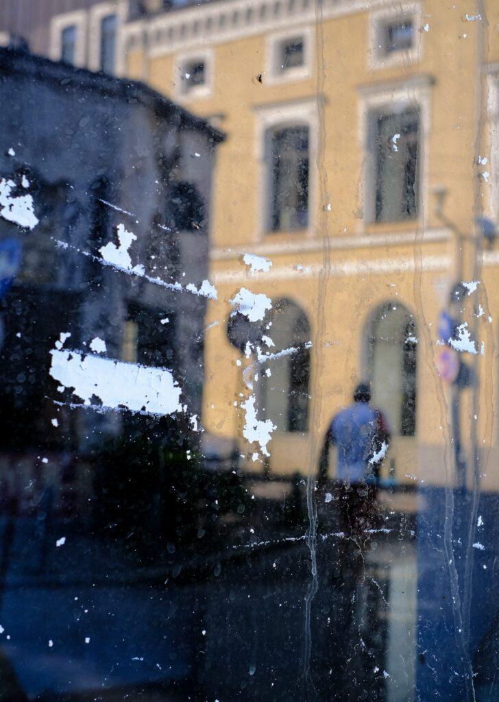 Man reflection on a dirty window in Bucharest Romania