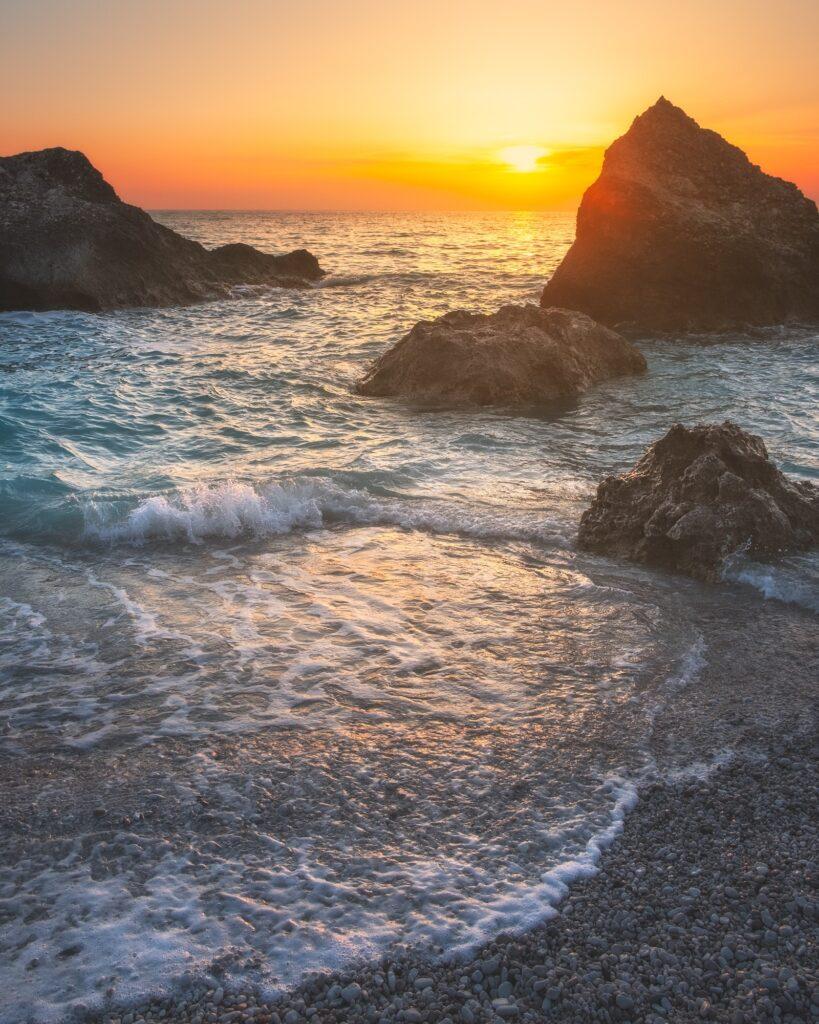 Waves hitting the rocky coast at sunset in Lefkada Greece