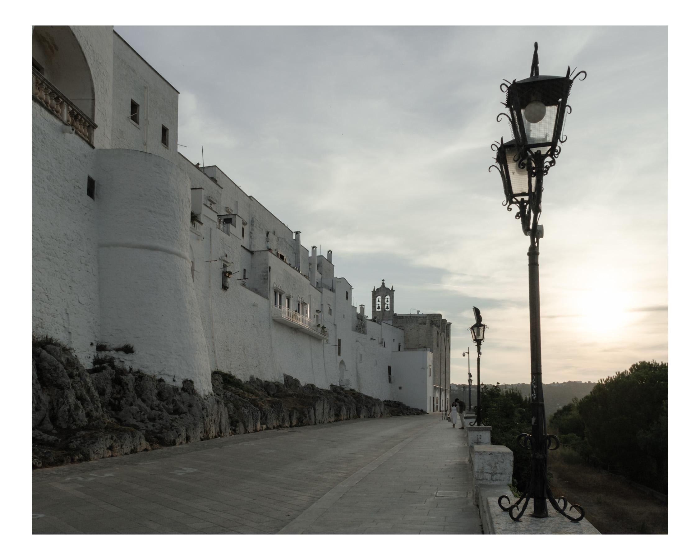 Couple walking close to sunset near Ostuni's walls in Ostuni Puglia