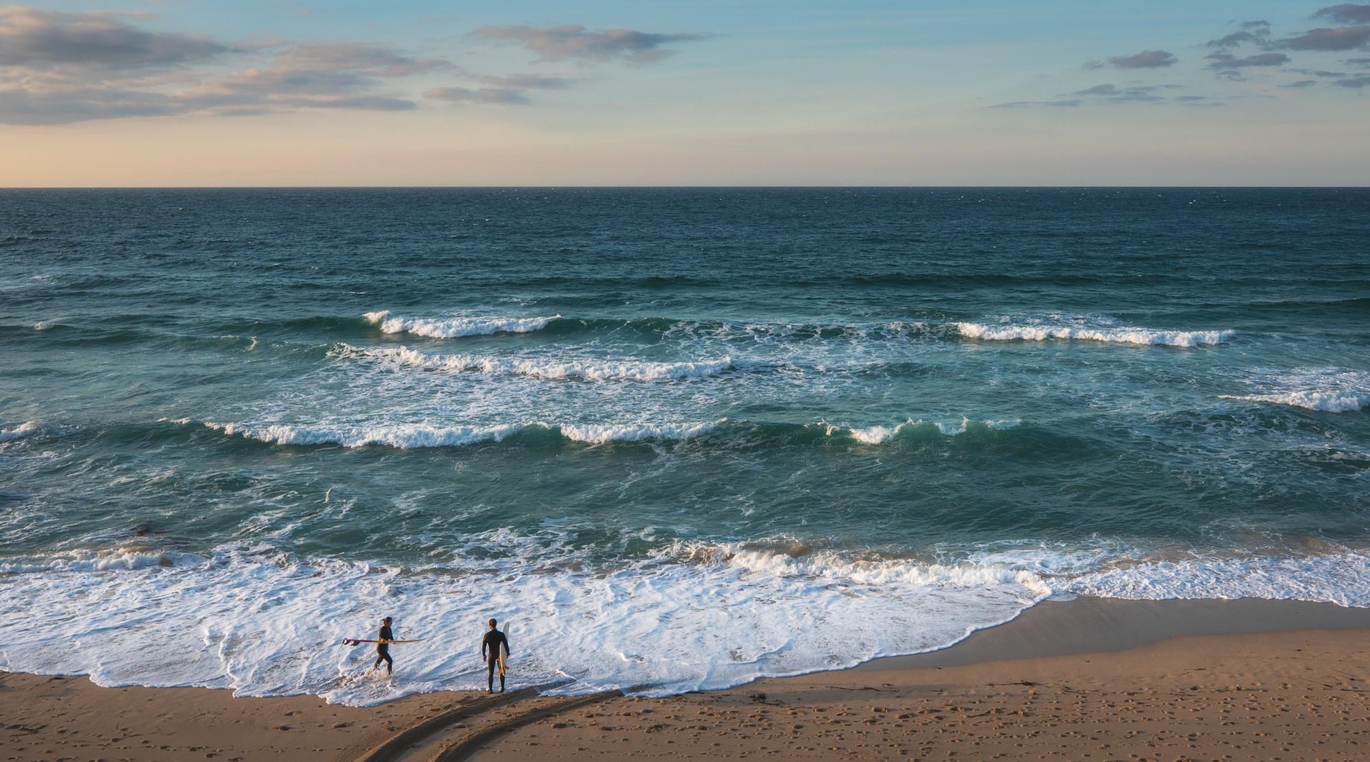 Two surfers on the beach in Saint Ives, Cornwall England