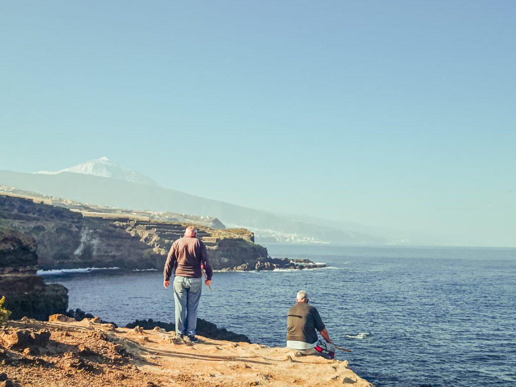 People enjoying the sunny days on the coast of Tenerife iverlooking Teide in the distance in Tenerife