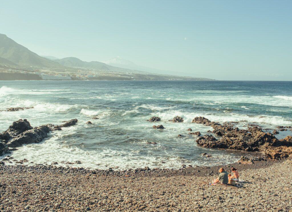 People enjoying the weather on a small beach in Northern Tenerife with Teide as background in Tenerife