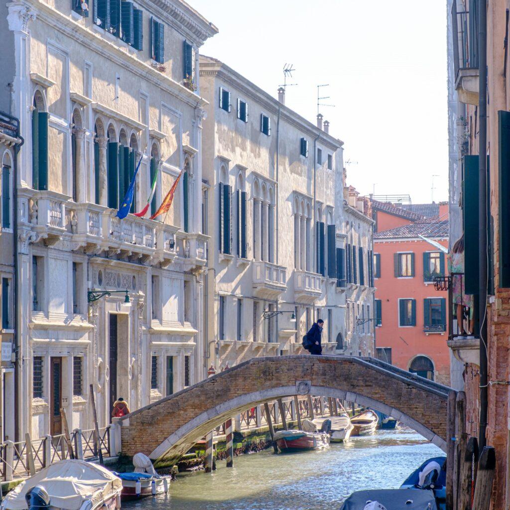 People crossing one of the hundreds of bridges in Venice Italy