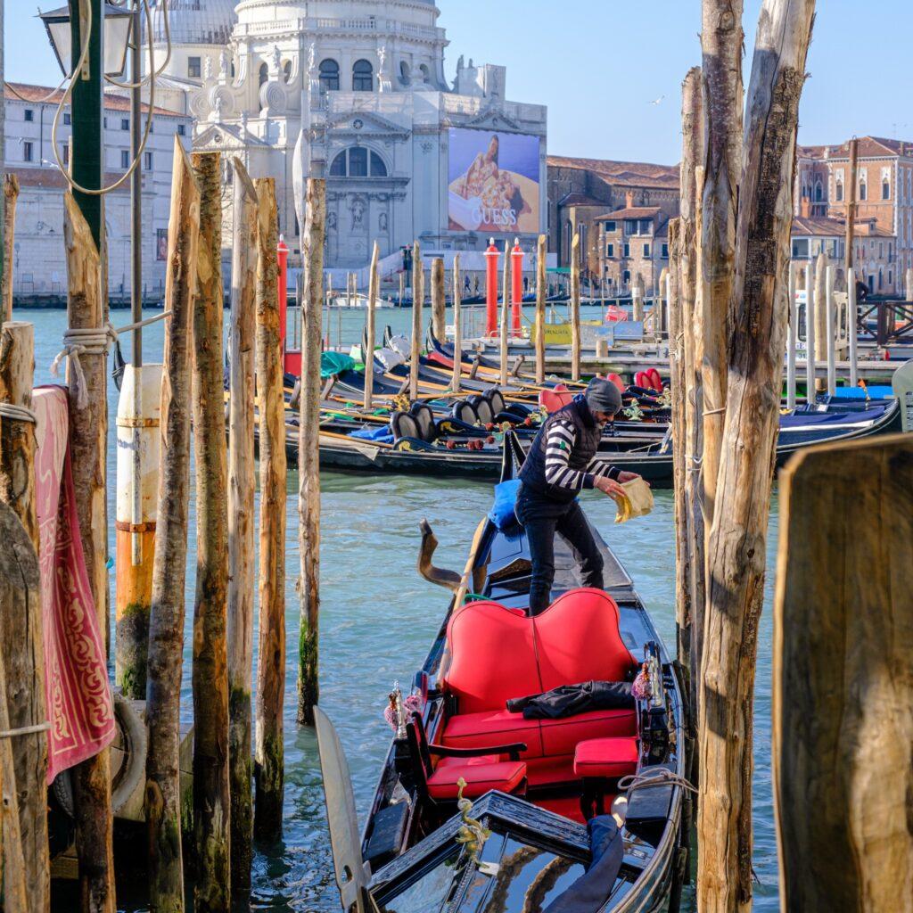 Gondolier preparing his gondola for clients in Venice Italy