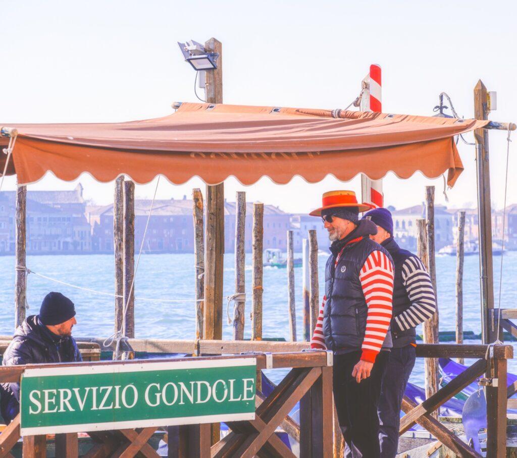 Street photography scene in Venice harbor with gondolas and gondoliers